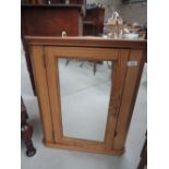 A pine corner cabinet with mirror door
