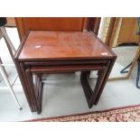 A vintage mahogany nest of three tables