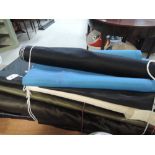 A selection of bolts of fabric, mainly lining type fabrics, in a variety of colours and sizes