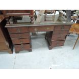 An Edwardian mahogany desk having drawer recess flanked by pedestal drawers