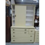 A late 19th early 20th century painted pine kitchen cabinet with sliding doors and drawers under