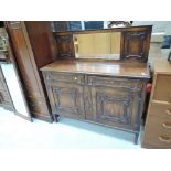 An early 20th Century oak panelled low mirror back sideboard