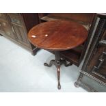 A 19th century mahogany pedestal table having circular flip top on reeded column and triple splay