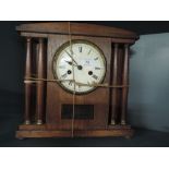 A Victorian oak bodied clock with column design and enamel face