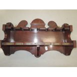 A mahogany pipe rack with brass day of the week plaques