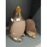 A life size figure of a hedgehog and accompanying penguin