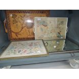 A selection of serving trays with various designs including pictoral wood and embroidery