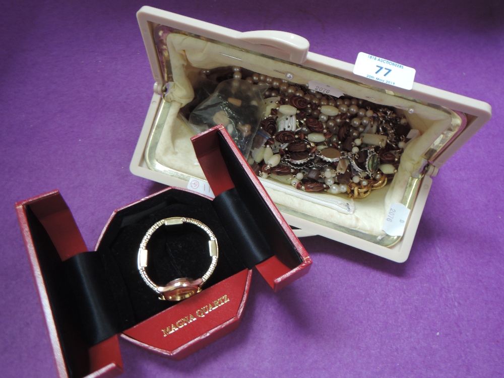 A cream clutch bag containing a selection of costume jewellery including a cased Magna wrist