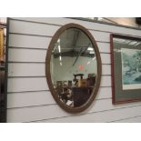 A stained frame oval wall mirror