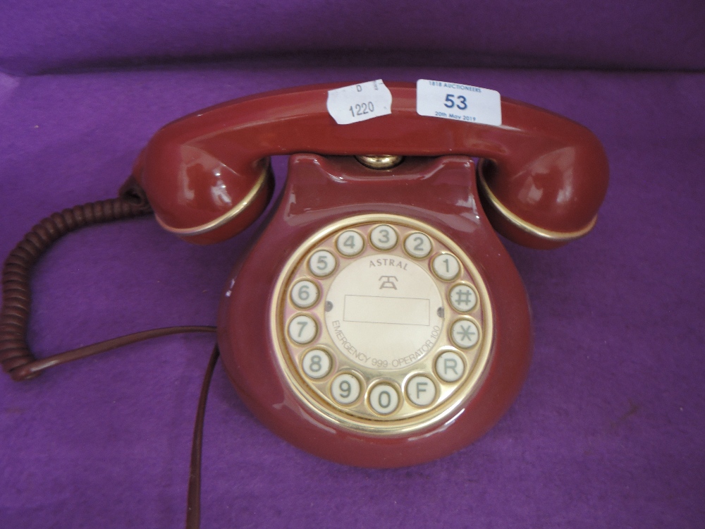 A red and gold plastic bodied telephone by Astral