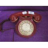 A red and gold plastic bodied telephone by Astral