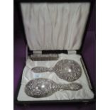 A cased HM silver four piece dressing table set having moulded mask and scroll decoration (af)