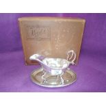 A silver plated sauce boat with saucer and ladle, all of traditional form, Viners Ltd, in original