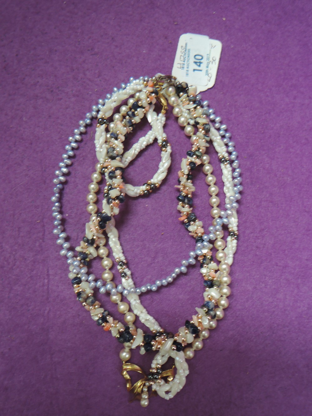 Five pieces of simulated pearl and stone jewellery including four necklaces and a bracelet