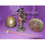 A cast figure of a Chinese merchant with gong and bell set