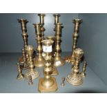 A selection of brass candle sticks including matching pairs and heavy cast