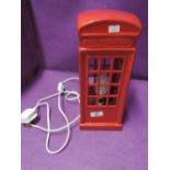 A table top lamp in the design of a red phone box