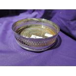 A silver plated bottle coaster of traditional form having gallery style side