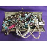 A beaded evening bag containing a selection of costume jewellery including a white metal bangle