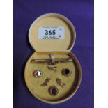 A cased gold plate and red paste trio of shirt buttons, and a yellow metal bar brooch stamped 9ct