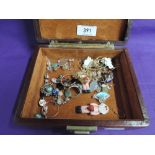 A small travel jewellery box containing a selection of fashion earrings including nude santa