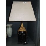 A cast lamp base in the form of a Buddah head