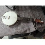 A vintage banjo ukulele , labelled John Grey, some fretmarkers missing and general restoration