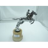 A jumping horse and jockey chrome car mascot mounted on an onyx base