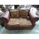 A Tetrad style part leather two seater sofa