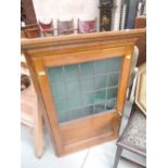 An early 20th century golden oak corner wall cupboard having opaque leaded glass panel door