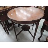 An Edwardian mahogany occasional table having petal top and undertier with scroll inlay on tapered