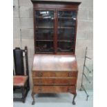 A glass fronted book shelf and bureau