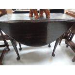 A 19th century daily oak dining table having oval drop leaf top on cabriole gate legs