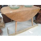 A vintage Ercol style beech drop leaf table on splay legs