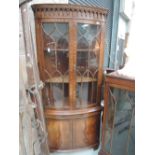 A bow fronted corner display cabinet