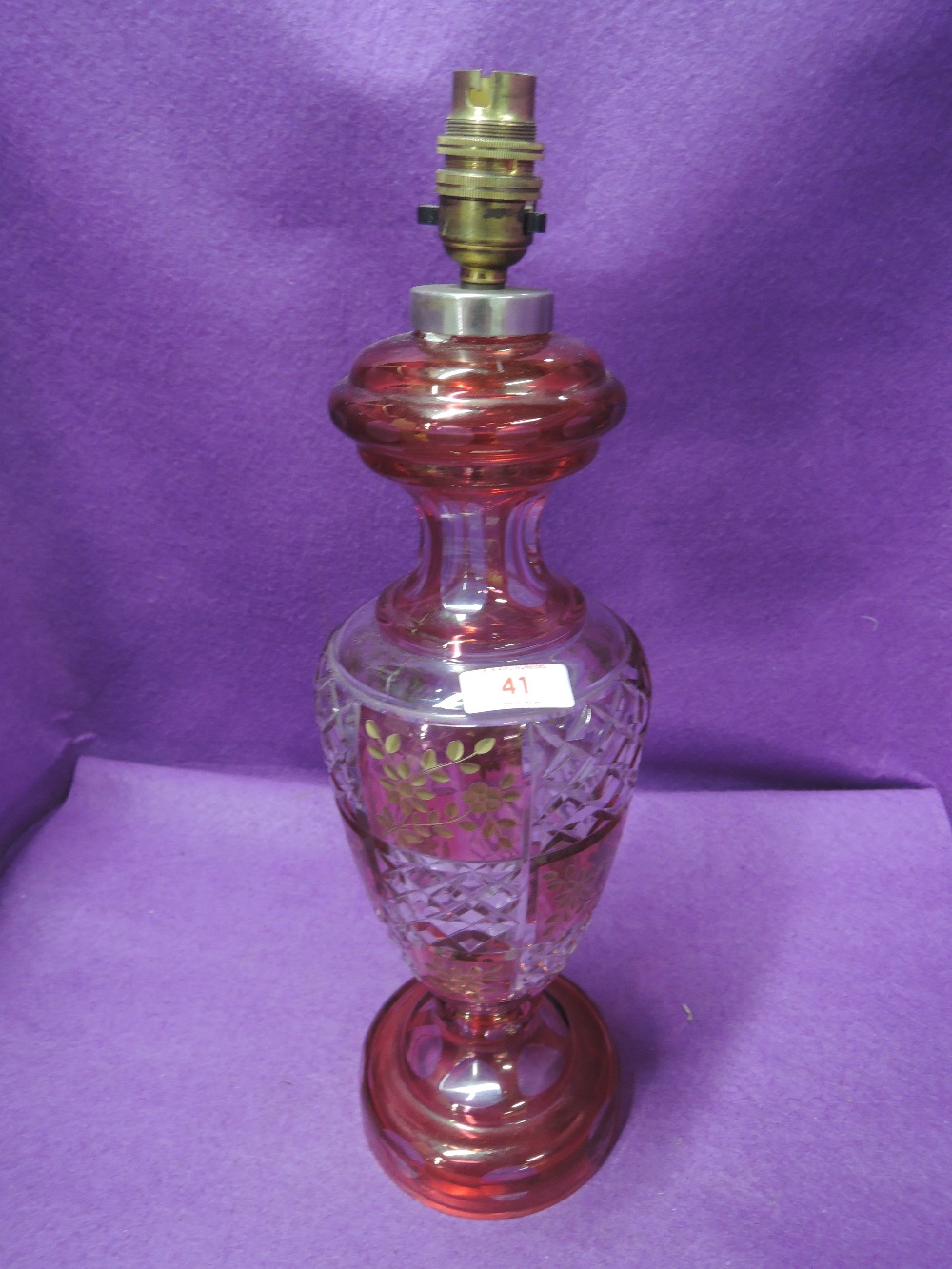 A 20th century ruby and clear glass table lamp having gilt heightened leaf decoration