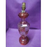 A 20th century ruby and clear glass table lamp having gilt heightened leaf decoration