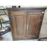 An early 19th century oak corner wall cupboard having panelled doors