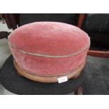 A 19th century mahogany frame circular footstool having later pink upholstery