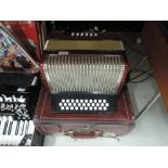 A Hohner button accordion in semi hard case