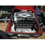 A Dino Baffetti button accordion, with hard travel case