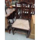 A pair of early 19th century elm vernacular chairs having camel and slat backs with later rush seats