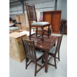 An early to mid 20th Century oak drawer leaf dining table and four chairs