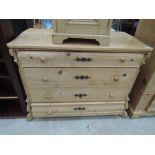 A stripped pine bombe style chest of 4 long drawers