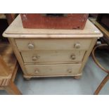 A stripped pine chest of 3 drawers