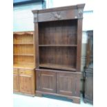 A dark stained bookcase with violin motif and double cupboard under