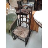 An early 20th century stained frame rocking chair having crest ladder back with rush seat and bobbin