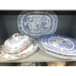 A selection of meat platters and tureens includes willow pattern