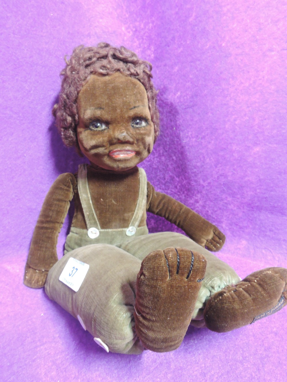 A soft bodied doll wearing dungarees