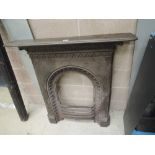 A Victorian cast iron fireplace with floral decor and integral mantle